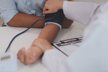 Doktor kadın nabız sayacını hastanın basıncını ölçmek için kullanıyor. Tıbbi kontrol konsepti..