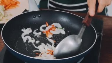 Yemek pişirme ve sağlıklı yiyecek konsepti - aşçı ellerinin tavada pişirilmesine yakın çekim