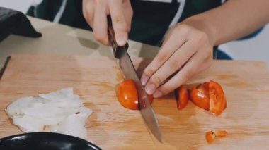 Mutfak tahtasında yemek pişirmek için sebze kesen kadınların ellerini kapatın.