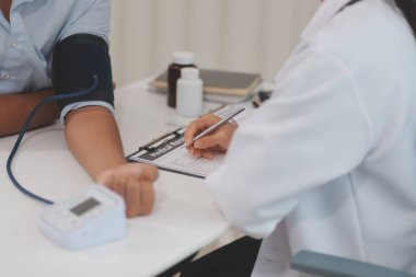 Doktor kadın nabız sayacını hastanın basıncını ölçmek için kullanıyor. Tıbbi kontrol konsepti..