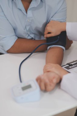 Doktor kadın nabız sayacını hastanın basıncını ölçmek için kullanıyor. Tıbbi kontrol konsepti..