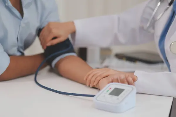 Doktor kadın nabız sayacını hastanın basıncını ölçmek için kullanıyor. Tıbbi kontrol konsepti..
