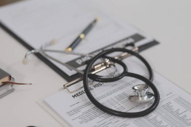 Doktor dizüstü bilgisayarda çalışıyor, reçeteli pano yazıyor hastane ya da klinikteki masalarda, sağlık hizmetlerinde ve tıbbi konseptte kayıt bilgi klasörleri yazıyor. Steteskopa odaklan.