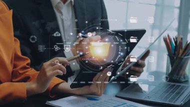 Akıllı telefon ve sanal diyagramı olan dizüstü bilgisayarla çalışan bir işadamı. Ofisteki ahşap masanın üzerinde diyagram şeması var..