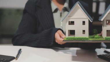 Ev modeli ve hesap makinesine sahip iş adamı