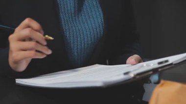 İşadamı defter kağıdına el yazısı yazıyor.