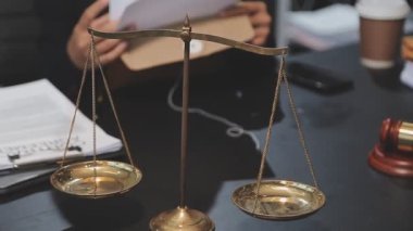 Yargıç Tokmak ve adalet terazisi. Masada hukuk kitabı var..