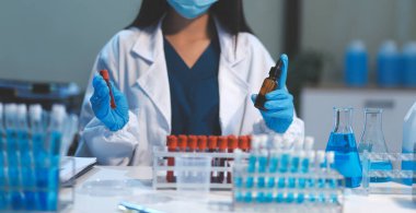 Kendini adamış bir grup bilim adamı tıbbi laboratuvarda kimyasal deney yapıyor. Aşı ilacı veya antibiyotik geliştirmek için pipetten deney tüpüne kesin miktarda sıvı döküyorlar. Neoterik