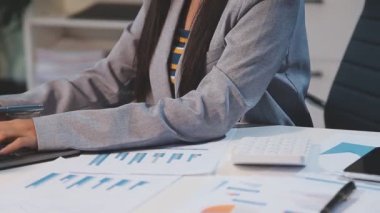 Finansal belgeleri, bilgisayarı, hesap makinesi ve telefonu olan bir iş kadını.