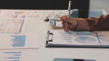 Genç adam ofiste iş belgeleri üzerinde çalışıyor.