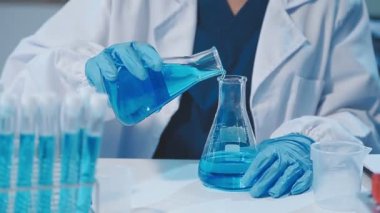 Laboratuvarda sıvı şişesi olan bilim adamı, yakın plan. kimya araştırması