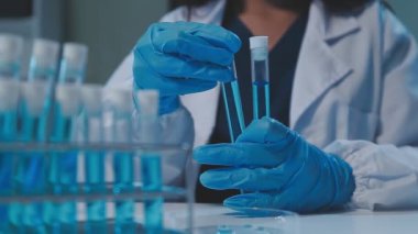 Laboratuvar bilim adamı laboratuarda test tüpleriyle çalışıyor.