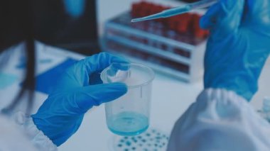 Bilim adamı bir test tüpü tutuyor ve bir sıvının analizini yapıyor.