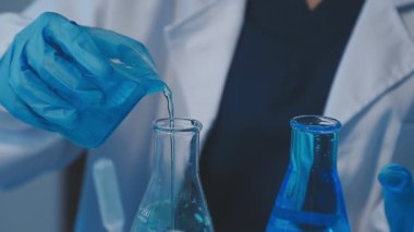 Bilim adamı sıvı, kimyasal laboratuvar konseptiyle test tüpü tutuyor..