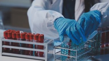 Kimya laboratuvarında sıvı içeren test tüpü tutan bilim adamı.