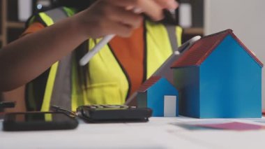 Ofiste bilgisayarla çalışan kadın mühendis tablet ve hesap makinesiyle, iş konsepti