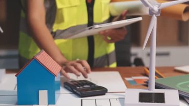 Mimar masanın üzerinde bir planla çalışıyor. Emlak kavramı