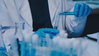 Modern laboratuarda yüksek teknolojili ekipmanlarla çalışan kadın bilim adamı.