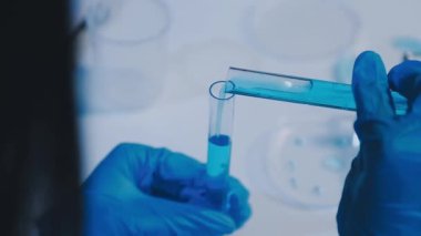 Modern laboratuarda yüksek teknolojili ekipmanlarla çalışan kadın bilim adamı.