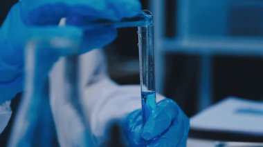 Kadın araştırmacı, modern laboratuardaki yüksek teknoloji malzemeleriyle örnekleri analiz ediyor.