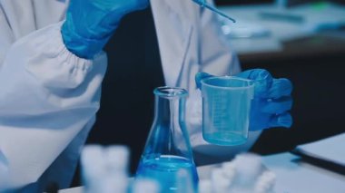 Kadın araştırmacı, modern laboratuardaki yüksek teknoloji malzemeleriyle örnekleri analiz ediyor.