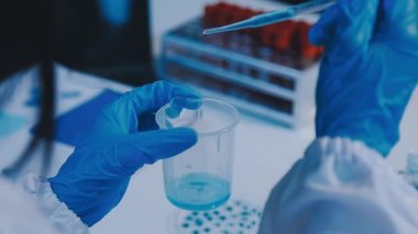 Kadın araştırmacı, modern laboratuardaki yüksek teknoloji malzemeleriyle örnekleri analiz ediyor.