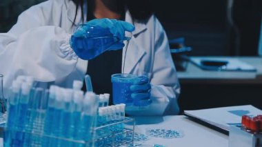 Kadın araştırmacı, modern laboratuardaki yüksek teknoloji malzemeleriyle örnekleri analiz ediyor.