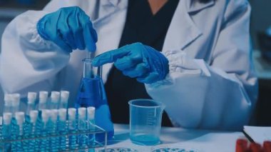 Kadın araştırmacı, modern laboratuardaki yüksek teknoloji malzemeleriyle örnekleri analiz ediyor.