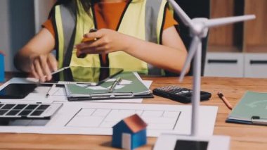 Ofis masasında taslak ve hesap makinesi olan kadın mimar mühendisi.