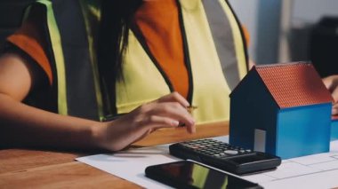 Genç Asyalı iş kadını planlar ve hesap makinesiyle çalışıyor.