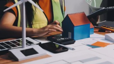 Ofisteki masada projeler, planlar ve hesap makinesiyle çalışan mimar, inşaat konsepti.