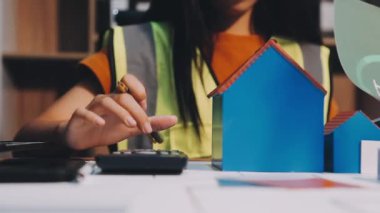 Genç Asyalı kadın mimar ofiste çalışıyor, emlak konsepti.