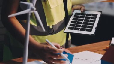 Ofiste inşaat projesinde çalışan kadın mimar mühendis tablet, dizüstü bilgisayar ve masa üzerindeki plan ve inşaat konseptini kullanıyor.