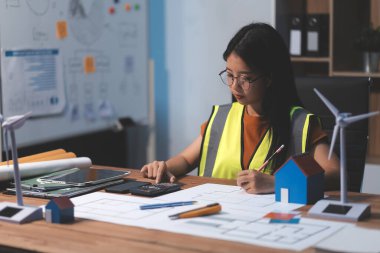 Evde çalışan kadın mimar planlara baktı..