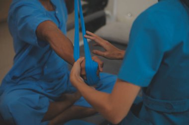 Profesyonel fizyoterapist genç bir adamı muayene eder ve tedavi eder. Hastanedeki bir adamın kaslarını ve yaralarını tedavi eder..