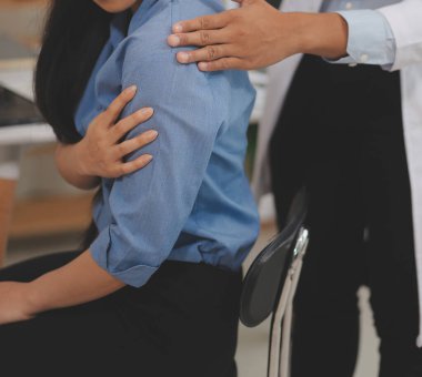 Doktor ya da fizyoterapist, sporcu erkek hastaların yaralı kollarını tedavi ediyor, esneme ve egzersiz yapıyor, klinikte rehabilitasyon tedavisi uyguluyor..