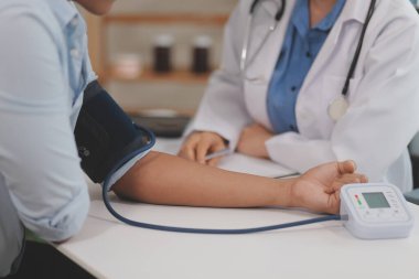 Doktor kadın nabız sayacını hastanın basıncını ölçmek için kullanıyor. Tıbbi kontrol konsepti..