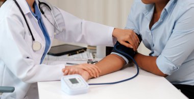 Doktor kadın nabız sayacını hastanın basıncını ölçmek için kullanıyor. Tıbbi kontrol konsepti..