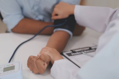 Doktor kadın nabız sayacını hastanın basıncını ölçmek için kullanıyor. Tıbbi kontrol konsepti..