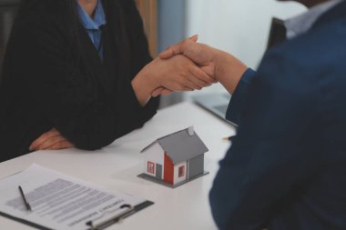 Emlak acentesi kontrat imzalandıktan sonra müşteriyle tokalaşıyor