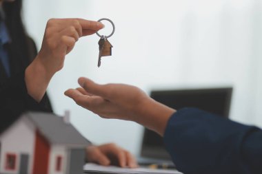 Konut kredisi teklifi ve konut sigortası için onaylı mortgage başvurusu formu ile sözleşme imzaladıktan sonra emlak acentesinin ev anahtarlarını müşteriye vermesi.