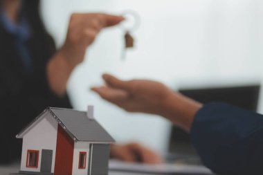 Konut kredisi teklifi ve konut sigortası için onaylı mortgage başvurusu formu ile sözleşme imzaladıktan sonra emlak acentesinin ev anahtarlarını müşteriye vermesi.