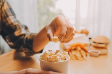 Elinde patlamış mısır kasesi tutan bir kadın.