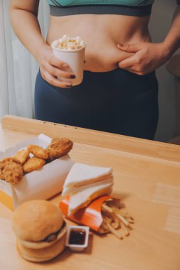 Yemek ya da değil. Burger bakarak cheerless tombul kadın yemek ya da değil düşünme