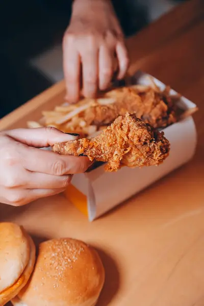 Odaklan kadın. Elin kızarmış tavuğu yemek için tutuyor. Fast food konsepti olan bir kız.