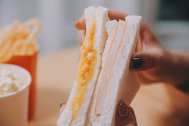 Asyalı sağlıklı bir kadın sabah sandviçle kahvaltı yapar.