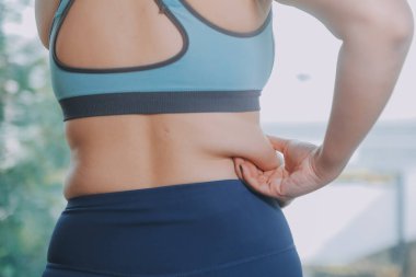 Şişman kadın, şişko, obez kadın el ele tutuşan ölçü bandıyla göbek yağı, kadın diyeti yaşam tarzı konsepti