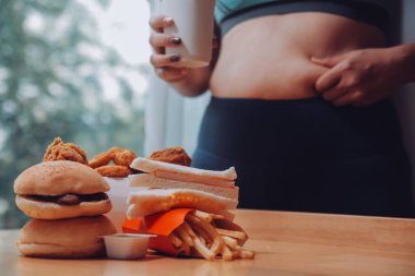 Yemek ya da değil. Burger bakarak cheerless tombul kadın yemek ya da değil düşünme