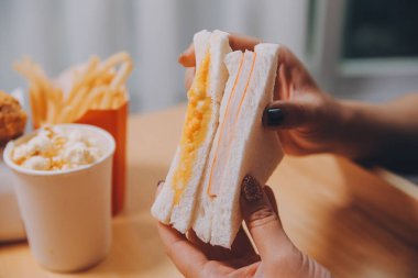 Asyalı sağlıklı bir kadın sabah sandviçle kahvaltı yapar.