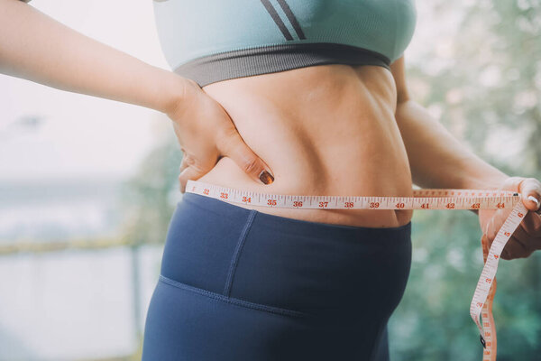 толстая женщина, жирный живот, пухлый, толстая женщина рука держит избыточный жир живота с помощью ленты, женщина диета образ жизни